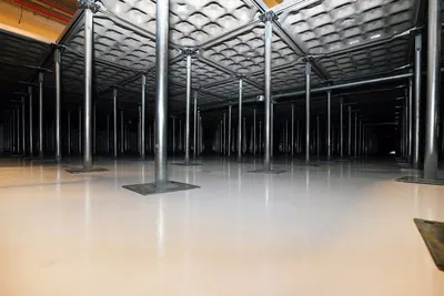Câmara sob o piso elevado, com filas de pedestais em profundidade
